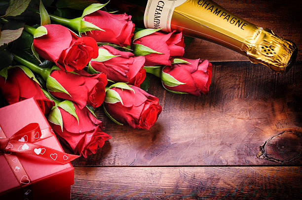 Configuração dos Namorados com rosas vermelhas, champanhe e presentes - foto de acervo
