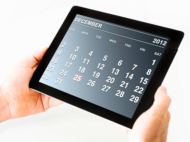 mann hält einen digitalen tablet und kalender dezember 2012 - new years eve new years day 2013 holiday stock-fotos und bilder