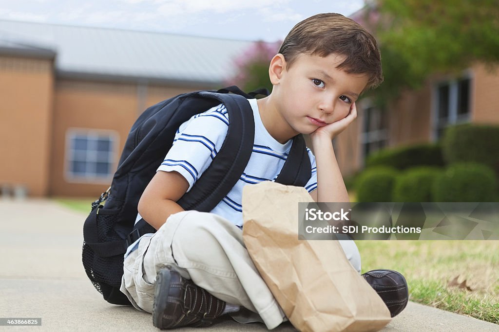Jovem criança sentada do lado de fora de sua escola - Foto de stock de Almoço royalty-free