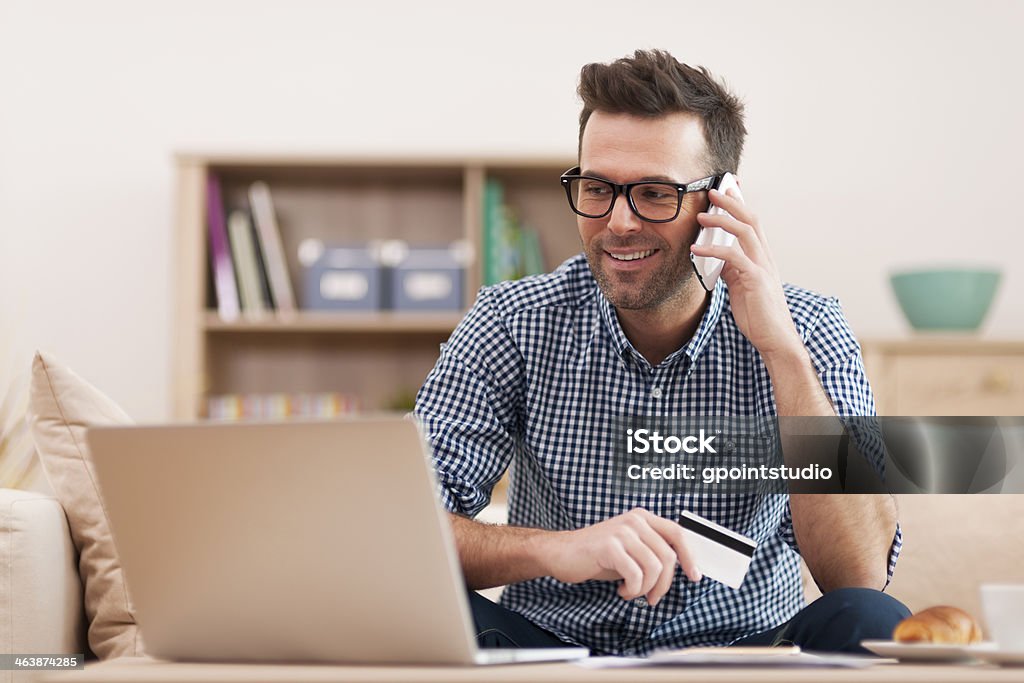 Uomo sorridente che Ordina per telefono cellulare - Foto stock royalty-free di Uomini