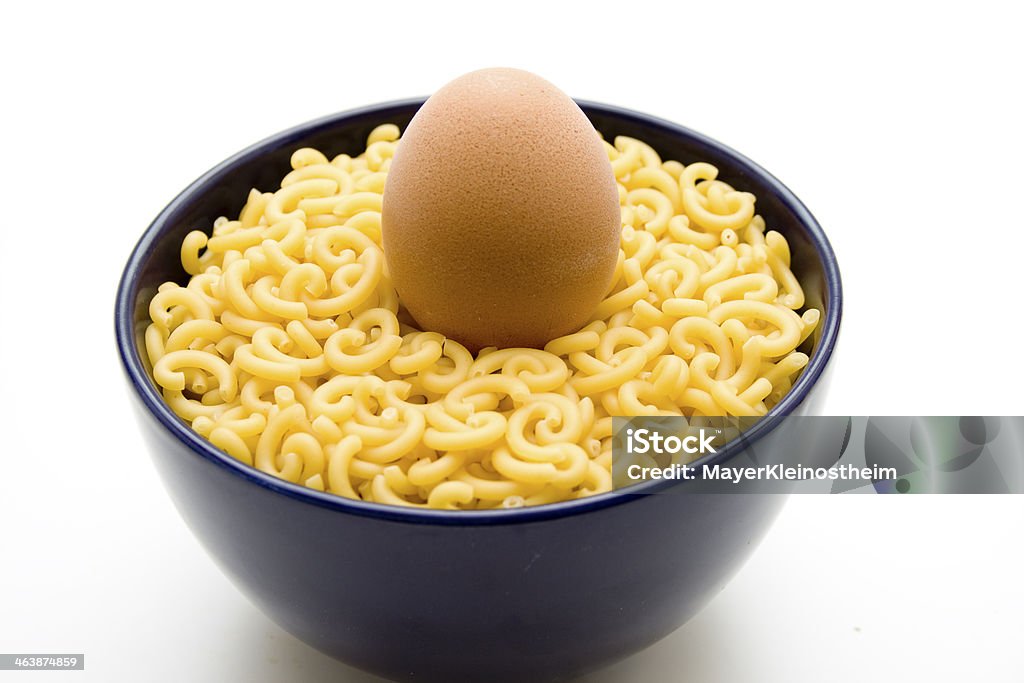 Elbow pasta with egg in blue bowl Elbow pasta with egg in blue bowl and on white background Blue Stock Photo