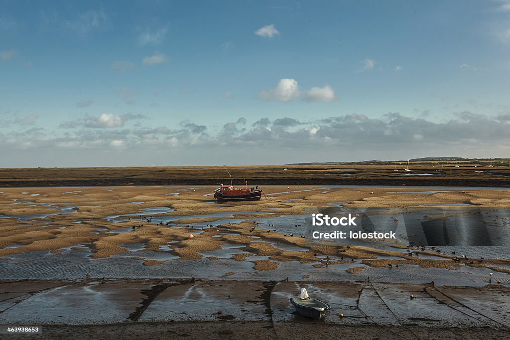 Fishing boat anchored at low tide Fishing boat anchored at low tide on the British coast Anchor - Vessel Part Stock Photo