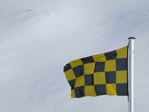 Chequered avalanche flag in mountains