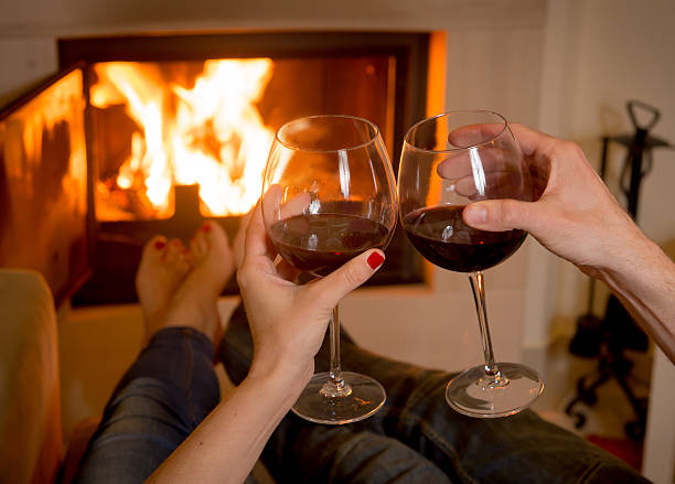 istock Romantic couple enjoying wine in front of the fire  464037485