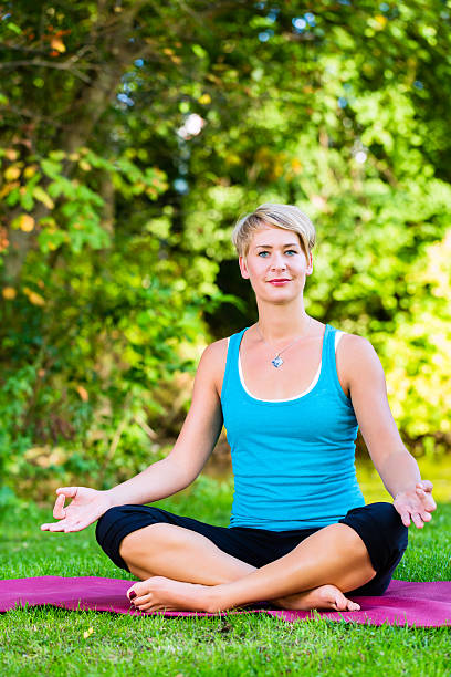 istock Young woman in nature doing yoga 464065803