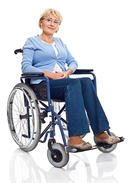 Mature woman in wheelchair Portrait of mature woman sitting in wheelchair and smiling at camera. Studio shot on white background. paraplegic stock pictures, royalty-free photos & images