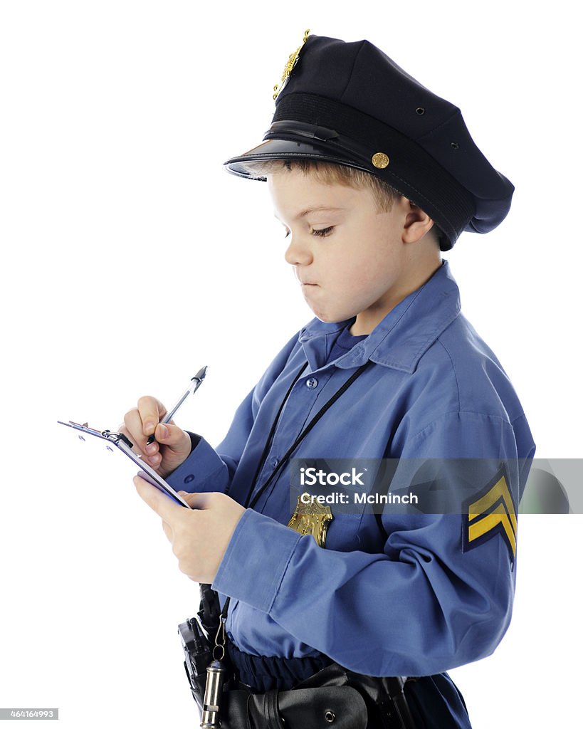 You Get a Ticket for That! A young elementary "policeman" intently writing a ticket.  On a white background. Child Stock Photo