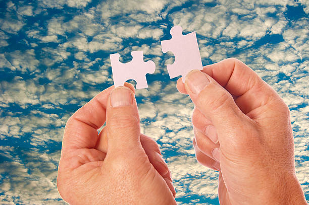manos conecte las piezas de puzzle con nubes - portion blue jigsaw puzzle puzzle fotografías e imágenes de stock