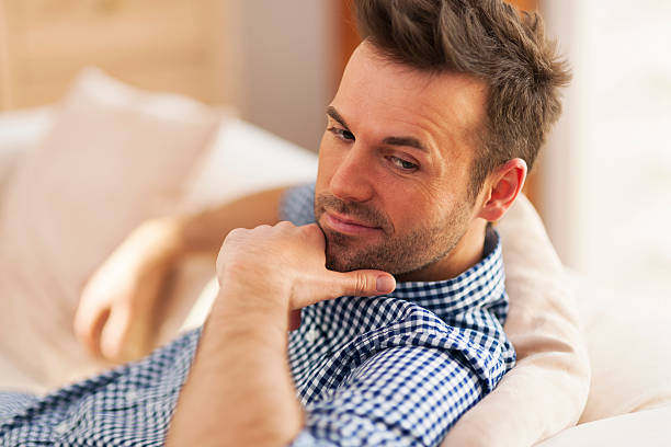 istock Portrait of handsome man sitting on sofa 464197017