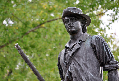A close-up of the famous Minute Man Statue is seen in this photo, sculpted by Daniel Chester French in 1875. This statue stands in Concord, Massachusetts on the very spot where the colonial militia gathered at North Bridge to stop the advancing British troops. Across North Bridge was fired \