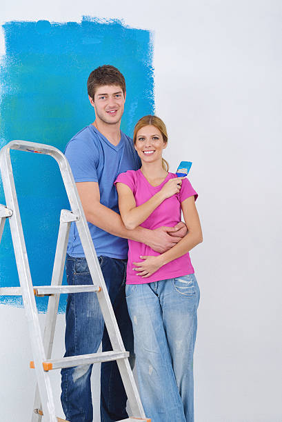 istock happy couple paint wall at new home 464199493