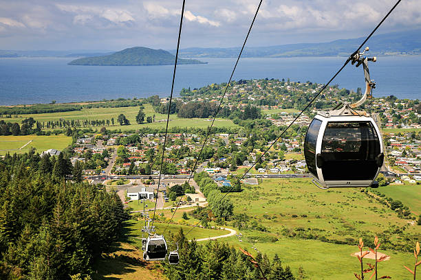 rotorua,new zealand Image of cable car with lake and mountains of  Rotorua, New Zealand in the background rotorua stock pictures, royalty-free photos & images