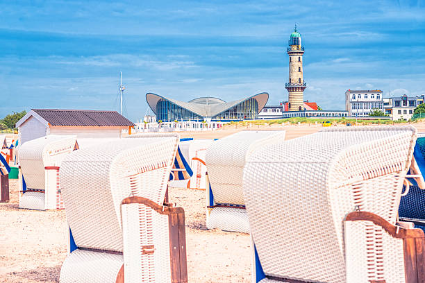 Warnemünde - Rostock View from the seaside on Warnemünde´s Hooded Beach Chair, landmark lighthouse, restaurant and hotel buildings. rostock photos stock pictures, royalty-free photos & images