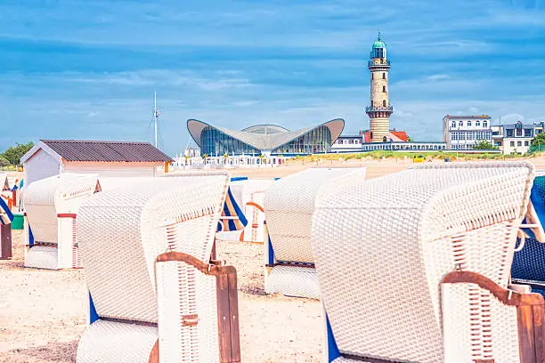 View from the seaside on Warnemünde´s Hooded Beach Chair, landmark lighthouse, restaurant and hotel buildings.