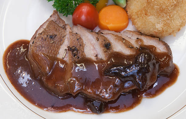istock Roasted duck with prune sauce on white plate 464217945