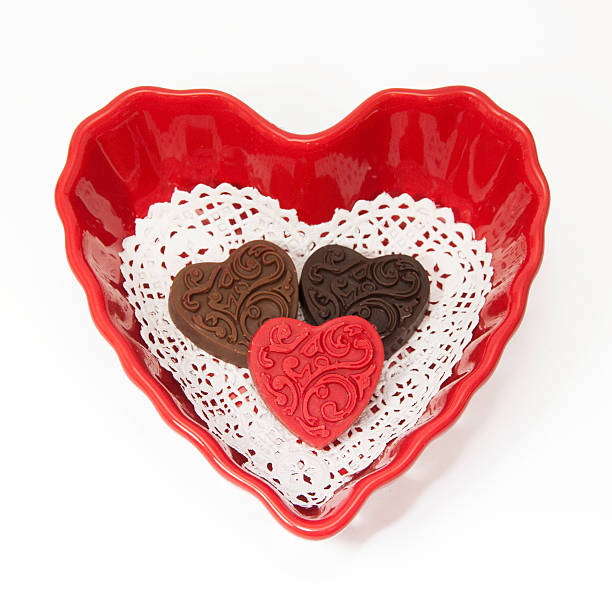 три шоколадных валентина в миску в форме сердца - doily candy bowl dishware стоковые фото и изображения