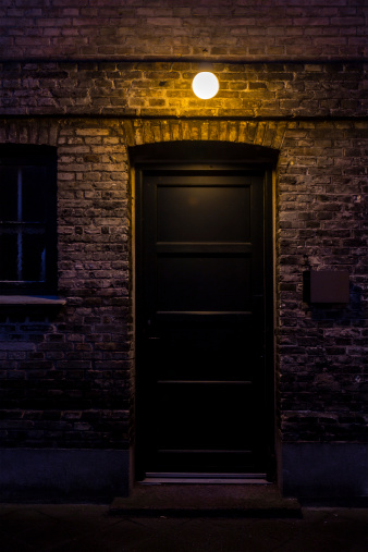 Black door in dark alley at night