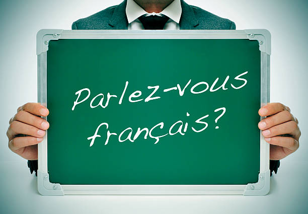 do you speak french? man wearing a suit holding a chalkboard with the question parlez-vous francais? do you speak french? written in it french language photos stock pictures, royalty-free photos & images