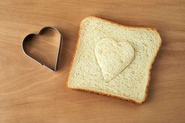 istock Slice of bread with cut out heart shape 464250857