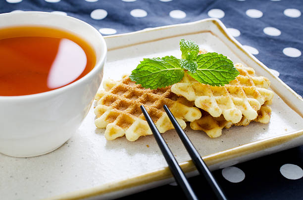 Tea with waffle and chopsticks in ceramic plate