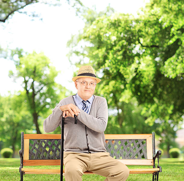 istock Senior man sitting on a wooden bench 464269211
