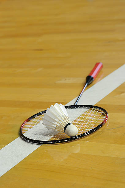 istock White shuttlecock lay down on racket in gymnasium 464272567
