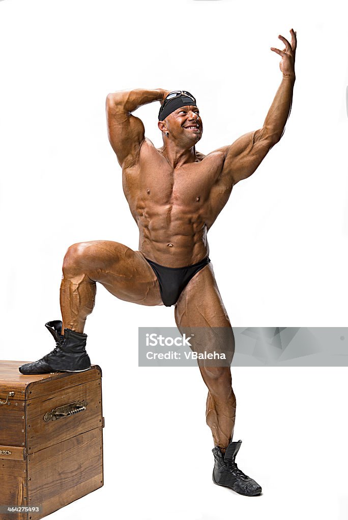 Bodybuilder posing near wooden chest Bodybuilder posing near wooden chest on a white background Box - Container Stock Photo