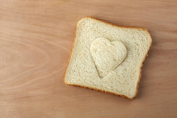 istock Slice of bread with cut out heart shape 464291483
