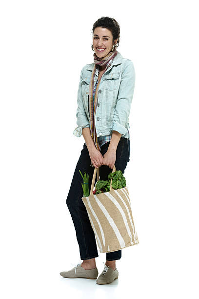 istock Cheerful woman standing with vegetables bag 464302437