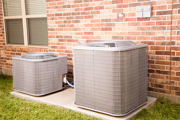Service Industry: Two air conditioner units outside home. stock photo