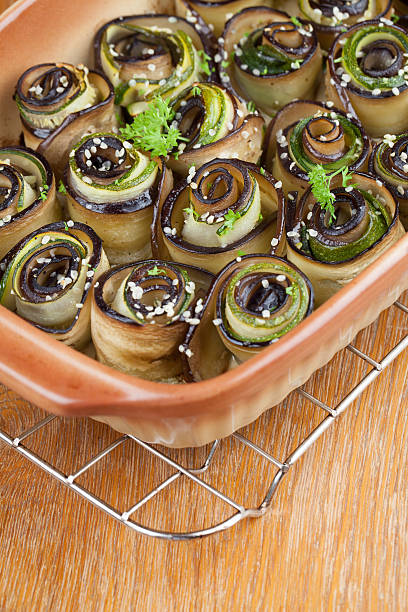 Eggplant and zucchini rolls on baking sheet with hemp seed. 