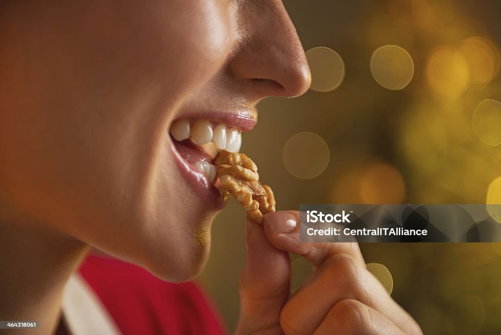 closeup on young housewife eating walnuts Closeup on young housewife eating walnuts Walnut Stock Photo