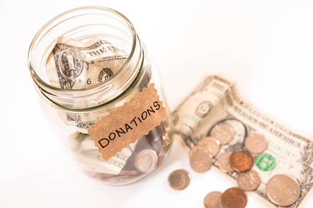 istock Volunteerism: Money Jar with coins, dollar bills. Help. Donation, fundraiser. 464319483