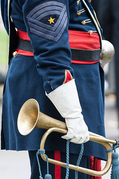 istock Bandsman in Blue Uniform with Red Sash Holding Brass Bugle 464319757