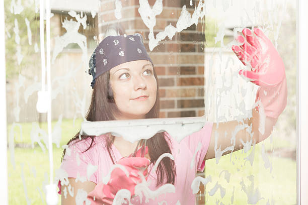 istock Domestic Life: Woman washes windows at personal home. 464322463
