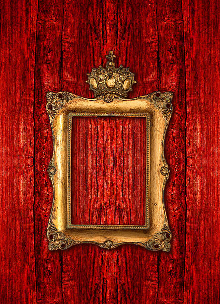 golden frame with crown over red wooden background