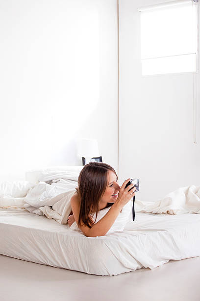 istock Smiling young woman taking a photo with old camera. 464343195