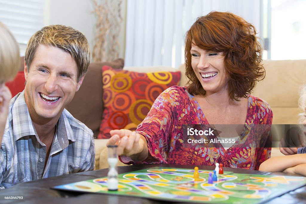 Mutter und Vater Lachen spielen ein Brettspiel für Kinder - Lizenzfrei Brettspiel Stock-Foto