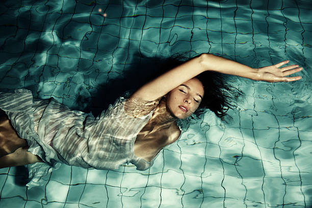 Girl swims in the pool at night stock photo