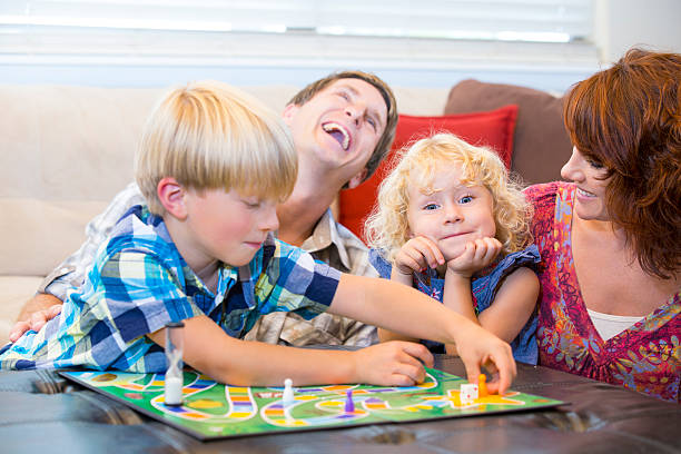 istock Family with two kids having fun playing board games 464358105