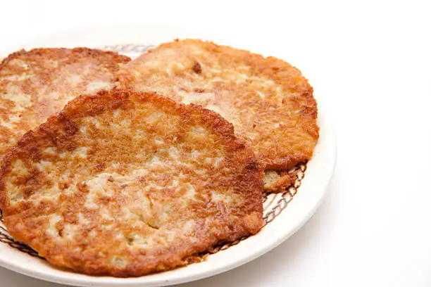 Potato pancakes on plate and on white background