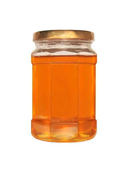 istock Jar of honey over a white background 464361489