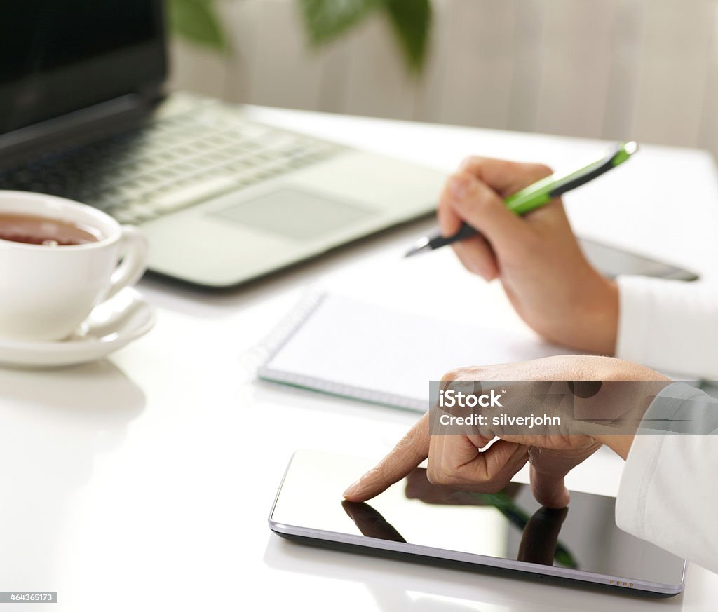 Woman hands with tablet PC and notepad at office Adult Stock Photo