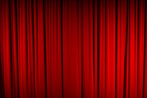Color, full frame image of a closed stage curtain, marking the beginning/end of a performance.