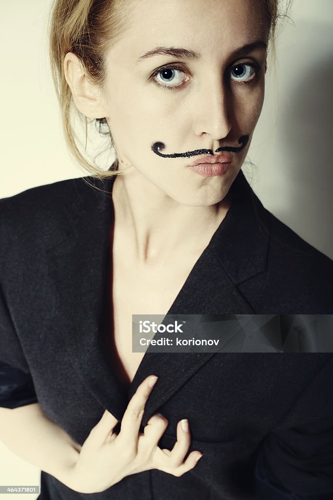 Young woman with painted mustache wearing jacket Portrait of young woman with painted mustache wearing jacket Actor Stock Photo