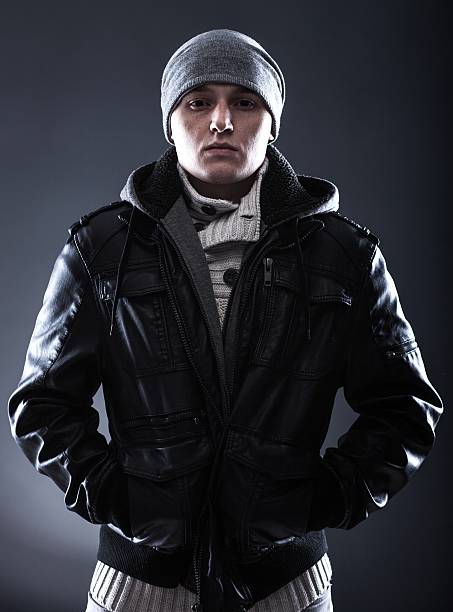 Scary hooligan young man in leather jacket Scary hooligan young man in leather jacket with hat larrikin stock pictures, royalty-free photos & images