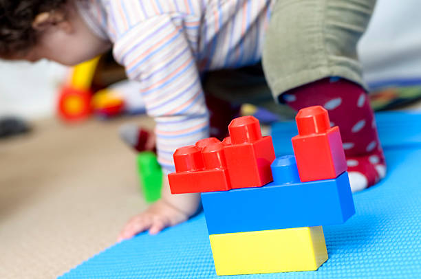 istock Baby Girl Playing With Plastic Building Blocks 464392549