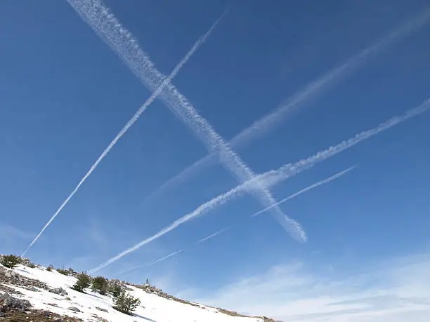 sky with vapor trail and mountain with snow