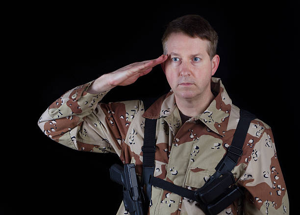 masculino soldier dando salute enquanto sob os braços - marines camouflage camouflage clothing male - fotografias e filmes do acervo