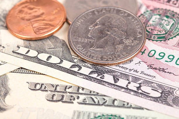 istock US coins on US banknotes close up 464396400